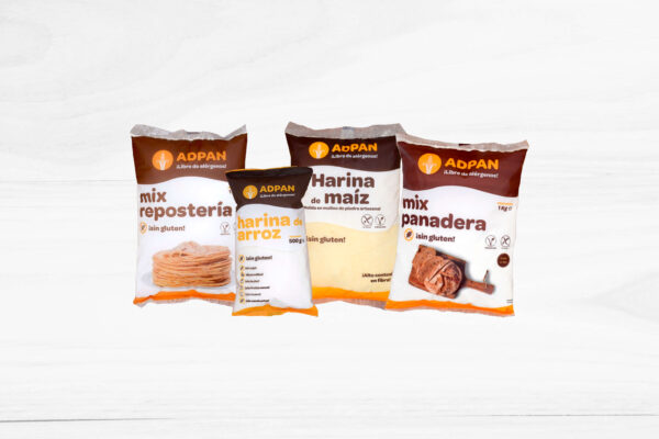 Pack de harinas variadas: mix de repostería, harina de arroz, harina de maíz y mix panadera, presentado sobre una superficie de madera con fondo neutro.