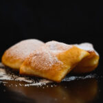 Casadielles de hojaldre sin gluten rellenas de nuez espolvoreadas con azúcar glacé