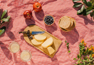 Picnic al aire libre con un mantel decorativo y una variedad de alimentos sin gluten y sin alérgenos sobre la mesa.