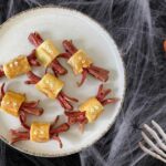 Arañas de Halloween hechas con masa de hojaldre sin gluten y salchichas y ojos comestibles.