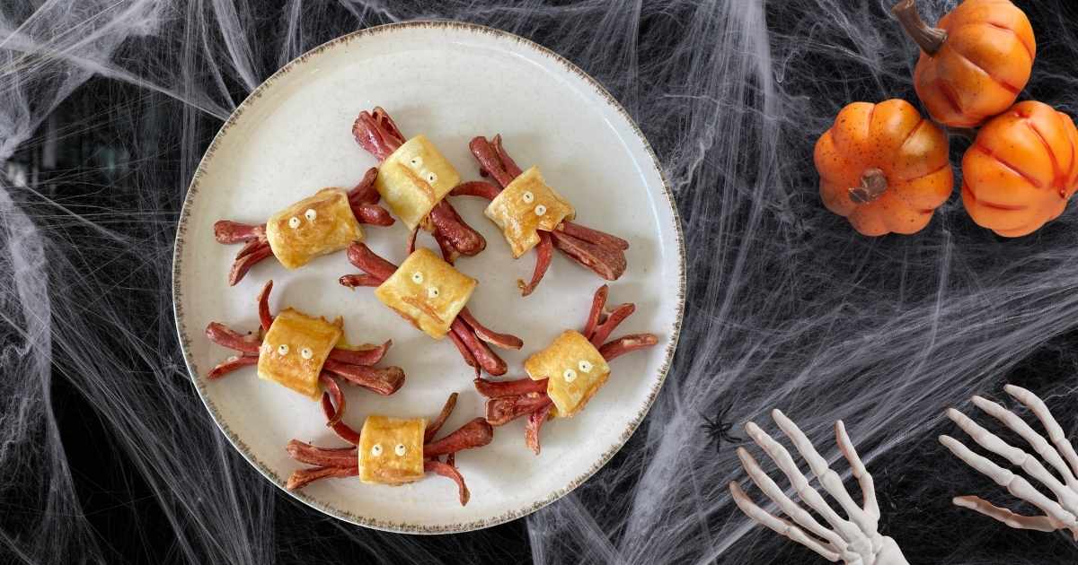 Arañas de Halloween hechas con masa de hojaldre sin gluten y salchichas y ojos comestibles.