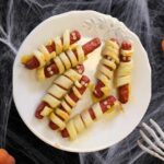 Salchimomias envueltas en masa de hojaldre sin gluten, horneadas y decoradas con ojos comestibles para Halloween.