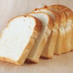 Pan de molde sin gluten en rebanadas sobre una tabla de madera