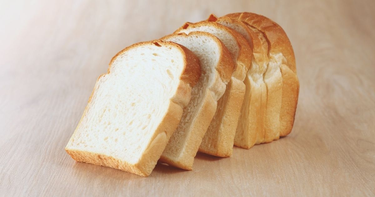 Pan de molde sin gluten en rebanadas sobre una tabla de madera