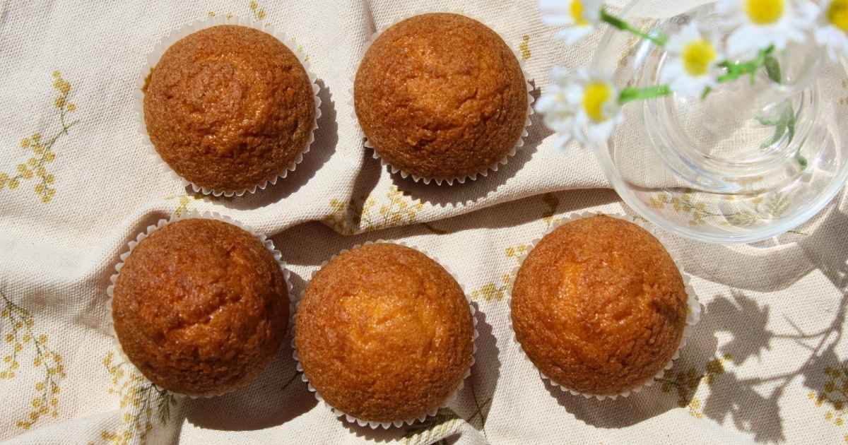 Magdalenas sin gluten caseras elaboradas con Mix Multiusos Adpan, recién horneadas y presentadas sobre un mantel de tela